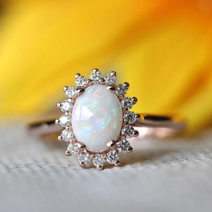 Anillo vintage en oro rosa con ópalo ovalado y borde en cristal radiante