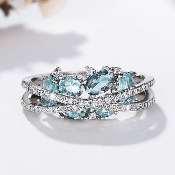 Anillo con cruz en plata y piedra preciosa azul