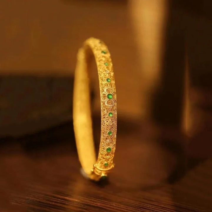 Armbånd med gyldne grønne ædelsten og etno blomstermønster
